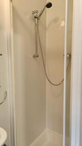 a shower with a glass door in a bathroom at Large Studio Garden Flat on Golders Green Road in London