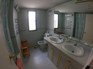 a bathroom with a sink and a mirror and a toilet at Piso Feria de Abril in Fuengirola