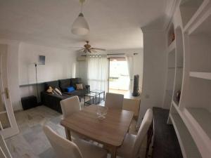 a living room with a table and chairs and a couch at Piso Feria de Abril in Fuengirola