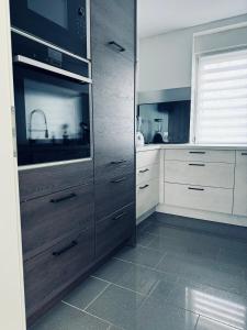 uma cozinha com gavetas de madeira e um micro-ondas em Apartment 110qm 3 Schlafzimmer 1 Wohnzimmer Garten em Wilhelmshaven