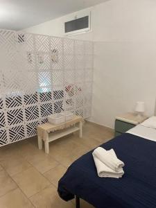 サント・ステーファノ・アル・マーレにあるVilla Chiaraのベッドルーム(青いベッド1台、ベンチ付)