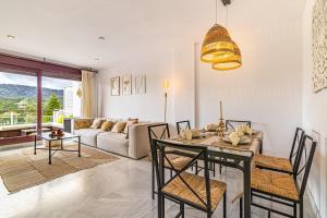 een eetkamer en een woonkamer met een tafel en stoelen bij RentitSpain Charming Apartment in Parque Botanico Resort & Country Club, Marbella, Estepona, Benahavis in Estepona
