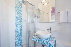 a bathroom with a sink and a glass shower at Hotel Eliseo in Bellaria-Igea Marina
