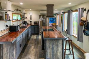 een grote keuken met houten aanrechtbladen in een huis bij Hummingbird Hideout in Port Orford