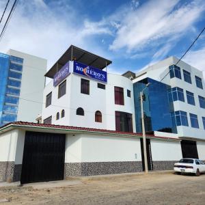 un edificio blanco con una señal azul encima en Hostal Nochero's, en Tacna