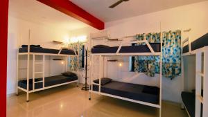 a room with three bunk beds in it at Mitra Hostel (By The Pool) in Vagator