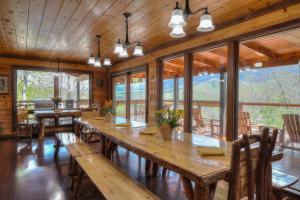 a large wooden table in a room with windows at 4 Seasons Lodge in Gatlinburg