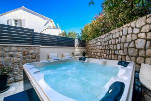 a hot tub in a backyard with a stone wall at Apartment Barbara with Private pool in Dubrovnik