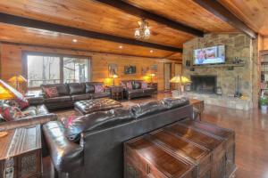 a living room with leather furniture and a stone fireplace at 4 Seasons Lodge in Gatlinburg