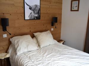 プラローニャン・ラ・ヴァノワーズにあるAppartement Pralognan-la-Vanoise, 3 pièces, 6 personnes - FR-1-464-12の枕2つと牛の写真付きベッド