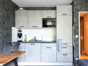 a kitchen with white cabinets and a wooden table at Apartment Düsseldorf-Lohausen II in Düsseldorf