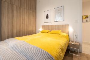 um quarto com uma cama com um cobertor amarelo em 2Homerent Shellter 117A em Rogowo