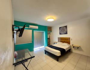 a bedroom with a bed and a glass table at Suites Brisa Marina - Playa Regatas y Malecón in Veracruz