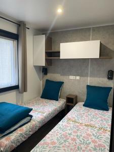 a room with two beds with blue pillows at A la brise du Ferret in Lège-Cap-Ferret