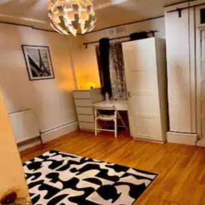 ロンドンにあるA little spot in the Cityのウッドフロアの客室で、白黒の敷物が敷かれています。