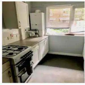 a small kitchen with a stove and a refrigerator at A little spot in the City in London