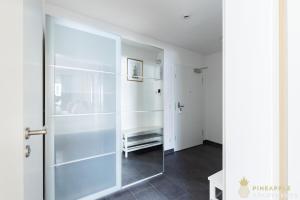 eine Glasduschtür in einem Zimmer mit Flur in der Unterkunft PINEAPPLE APARTMENTS - Studio-Apartment am Zwinger in Dresden
