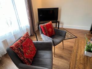a living room with a couch and a chair at Glastonbury Town Centre - Large 2 Bedroom Apt With Balcony in Glastonbury