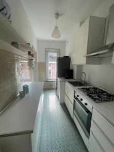 een keuken met witte werkbladen en een fornuis met oven bij Cadolini Apartment in Milaan