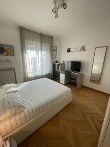 een slaapkamer met een bed, een bureau en een spiegel bij Cadolini Apartment in Milaan