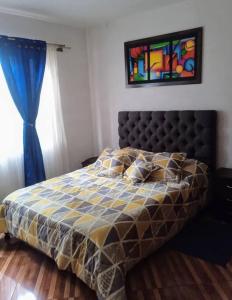 een slaapkamer met een bed en een raam met een schilderij bij Confortable Apartamento en Villa de Leyva in Villa de Leyva