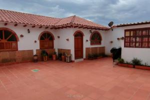 een wit huis met een rood dak en een patio bij Confortable Apartamento en Villa de Leyva in Villa de Leyva