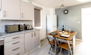 een keuken met een kleine tafel en een magnetron bij Spacious 3BR House with Garden & Free Parking in Manchester