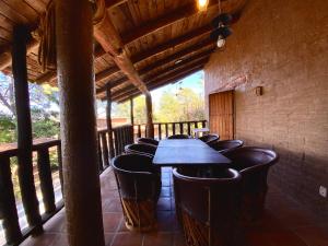 une salle à manger avec une table et des chaises sur une terrasse couverte dans l'établissement Aldea punta de agua, à Sayula