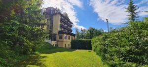 a large building on a hill with a green yard at Kurhotel Renona Rehabilitation in Semmering