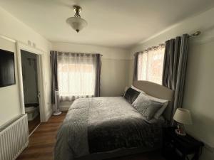 a bedroom with a bed and two windows at Glastonbury Town Centre - Large 2 Bedroom Apt With Balcony in Glastonbury