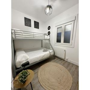 1 dormitorio con litera y alfombra en La Nueva Casa del Barco del Humo en Vigo