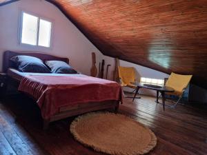 a bedroom with a bed in a attic with a window at la Maison rouge in Toliara