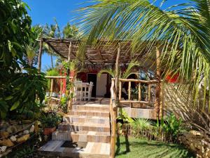 una pequeña casa con una escalera que conduce a ella en la Maison rouge en Toliara