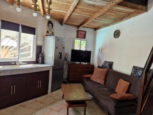a living room with a couch and a kitchen at la Maison rouge in Toliara