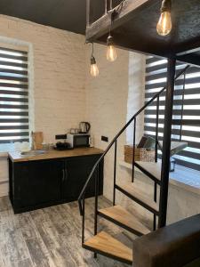 een keuken met een trap en een aanrecht met een magnetron bij Luxury_loft in Kamjanets-Podilsky