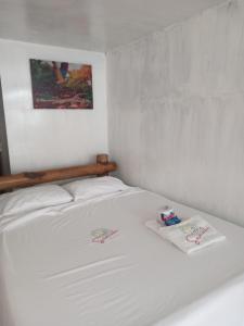 - un lit blanc avec 2 serviettes dans l'établissement Venido del Mar Turquesa White Beach Barù, à Carthagène des Indes