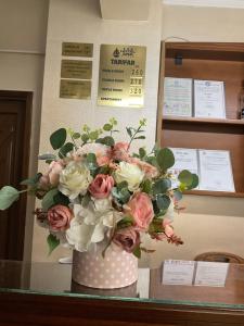 un jarrón lleno de flores rosas y blancas sobre una mesa en Hotel Ana, en Constanţa