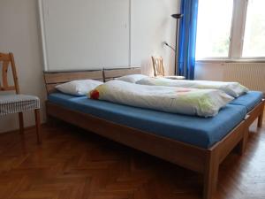 a bed with a blue sheet and pillows on it at BEST LOCATION IN BUDAPEST! in Budapest