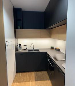 a kitchen with black cabinets and a white refrigerator at Altoria Active Gdynia in Gdynia