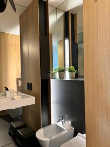 a bathroom with a sink and a toilet and a mirror at Altoria Active Gdynia in Gdynia