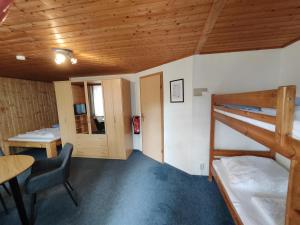 Zimmer mit einem Etagenbett, einem Schreibtisch und einem Tisch in der Unterkunft Kleine Freiheit Nummer 4 in Reichendorf