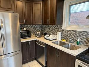 a kitchen with wooden cabinets and a stainless steel refrigerator at Enjoy luxury living in Mississauga