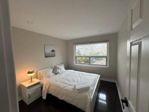 a small bedroom with a bed and a window at Enjoy luxury living in Mississauga