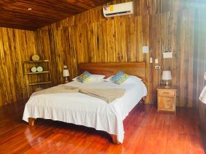 a bedroom with a bed in a wooden room at Cacahua Paradise Lodge, Río Celeste in Rio Celeste