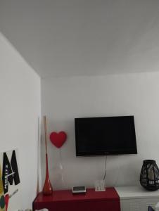 TV de pantalla plana en una pared blanca con armario rojo en Apartment Barca 1 Camp Nou, en Barcelona