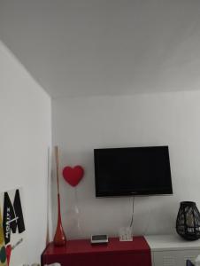 een flatscreen-tv op een witte muur met een rode kast bij Apartment Barca 1 Camp Nou in Barcelona