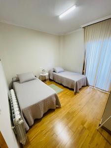 een slaapkamer met 2 bedden en een houten vloer bij VIVE HOME Vilanova de Arousa in Villanueva de Arosa