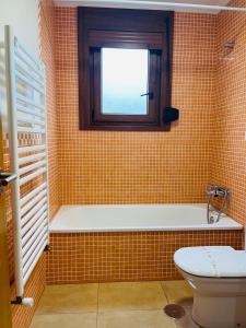 ein Bad mit einem Fenster, einer Badewanne und einem WC in der Unterkunft VIVE HOME Vilanova de Arousa in Vilanova de Arousa