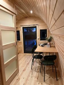 une chambre avec une table et des chaises dans une petite maison dans l'établissement Camping pod Tiny House aan het water, à Belt-Schutsloot
