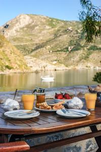 a table with plates of food and drinks on it at Porto Kale Guesthouse in Porto Kagio